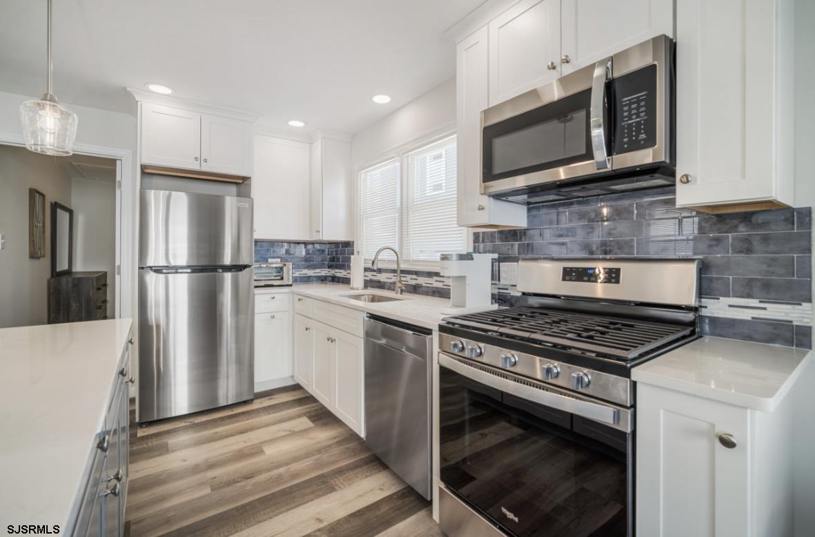 207 13th Street North Brigantine, NJ 08203 - Photo 8 of 44 a kitchen with stainless steel appliances granite countertop a stove a refrigerator and a microwave