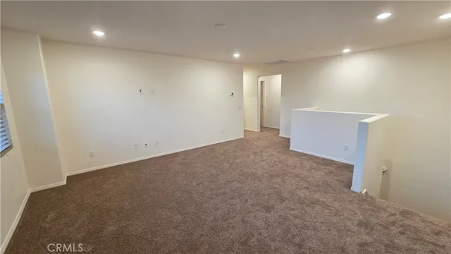 a white toilet sitting next to a white wall
