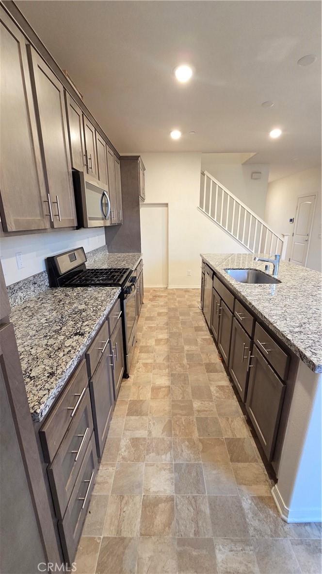 5321 Declan Street Riverside, CA 92504 - Photo 7 of 34 a kitchen with stainless steel appliances granite countertop a sink stove and cabinets