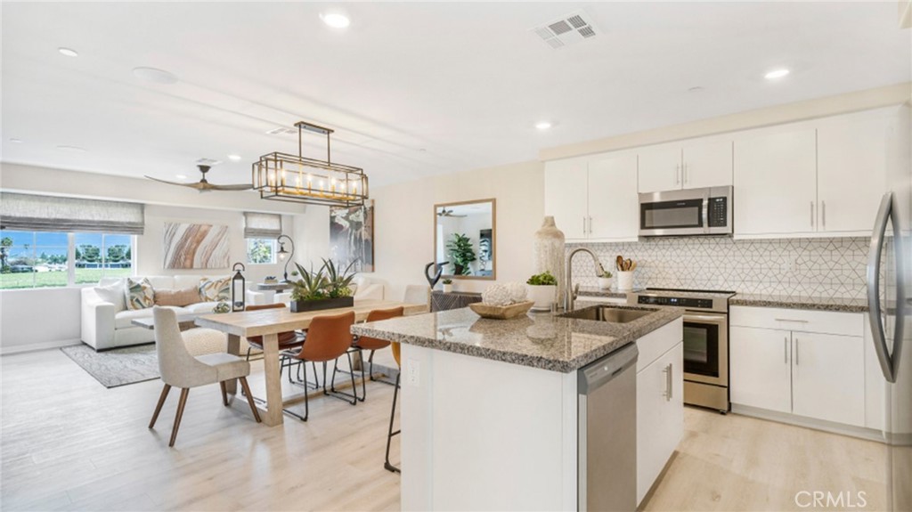 19152 Chestnut Grv Court Riverside, CA 92507 - Photo 4 of 14 a kitchen with a stove a sink a dining table and chairs