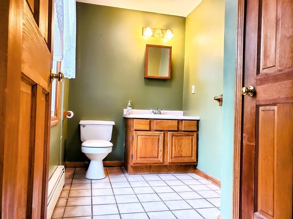 591 Podunk Road East Brookfield, MA 01515 - Photo 8 of 28 a bathroom with a toilet a sink and a mirror