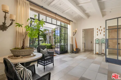 a living room with furniture and floor to ceiling windows