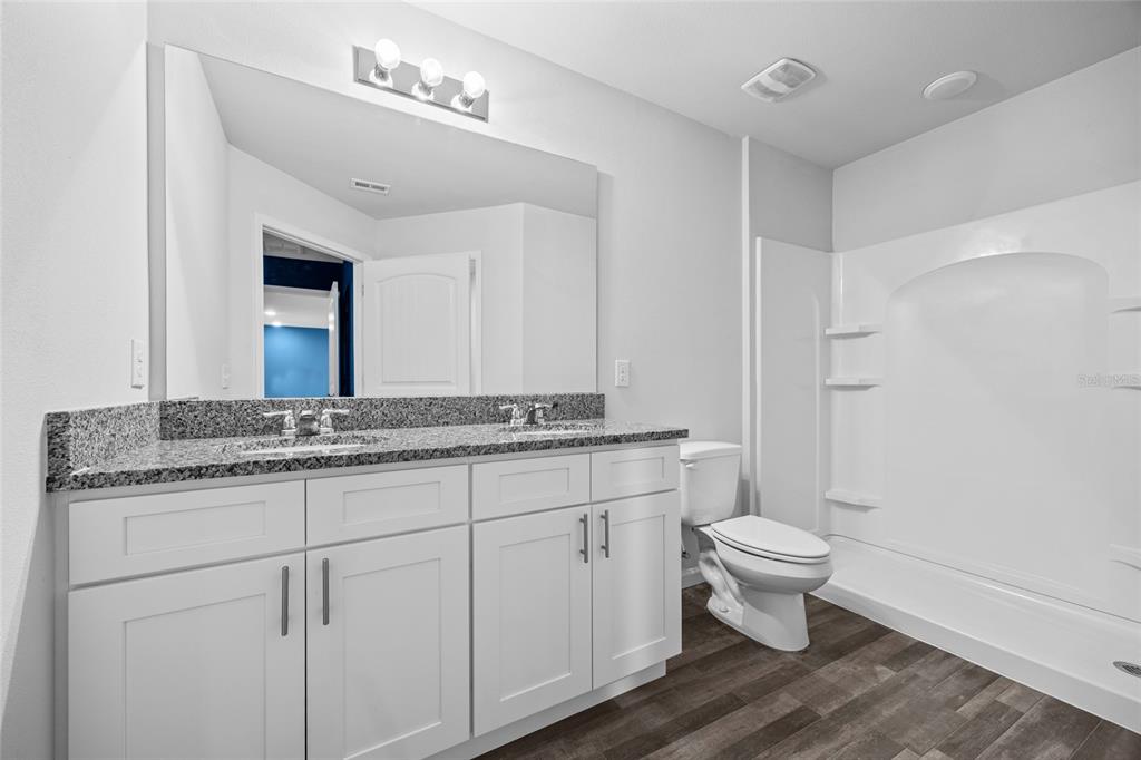 20105 Northwest 247th Street High Springs, FL 32643 - Photo 13 of 26 a bathroom with a granite countertop sink a toilet and a mirror