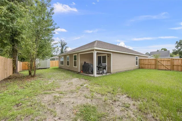a view of backyard with potted plants and large tree