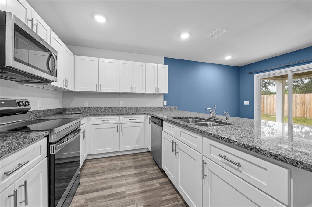 20105 Northwest 247th Street High Springs, FL 32643 - Photo 6 of 26 a kitchen with granite countertop cabinets stainless steel appliances and a counter space
