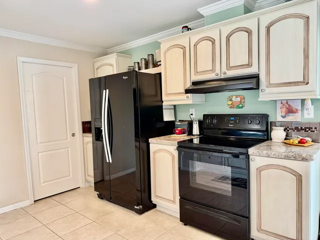 a kitchen with stainless steel appliances granite countertop a refrigerator a stove and a sink