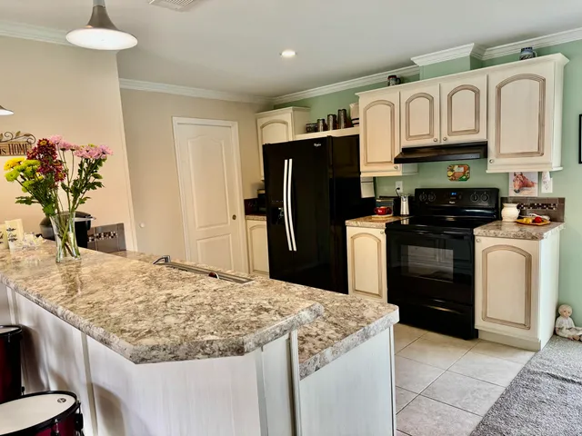 a kitchen with stainless steel appliances granite countertop a refrigerator oven stove a sink and dishwasher