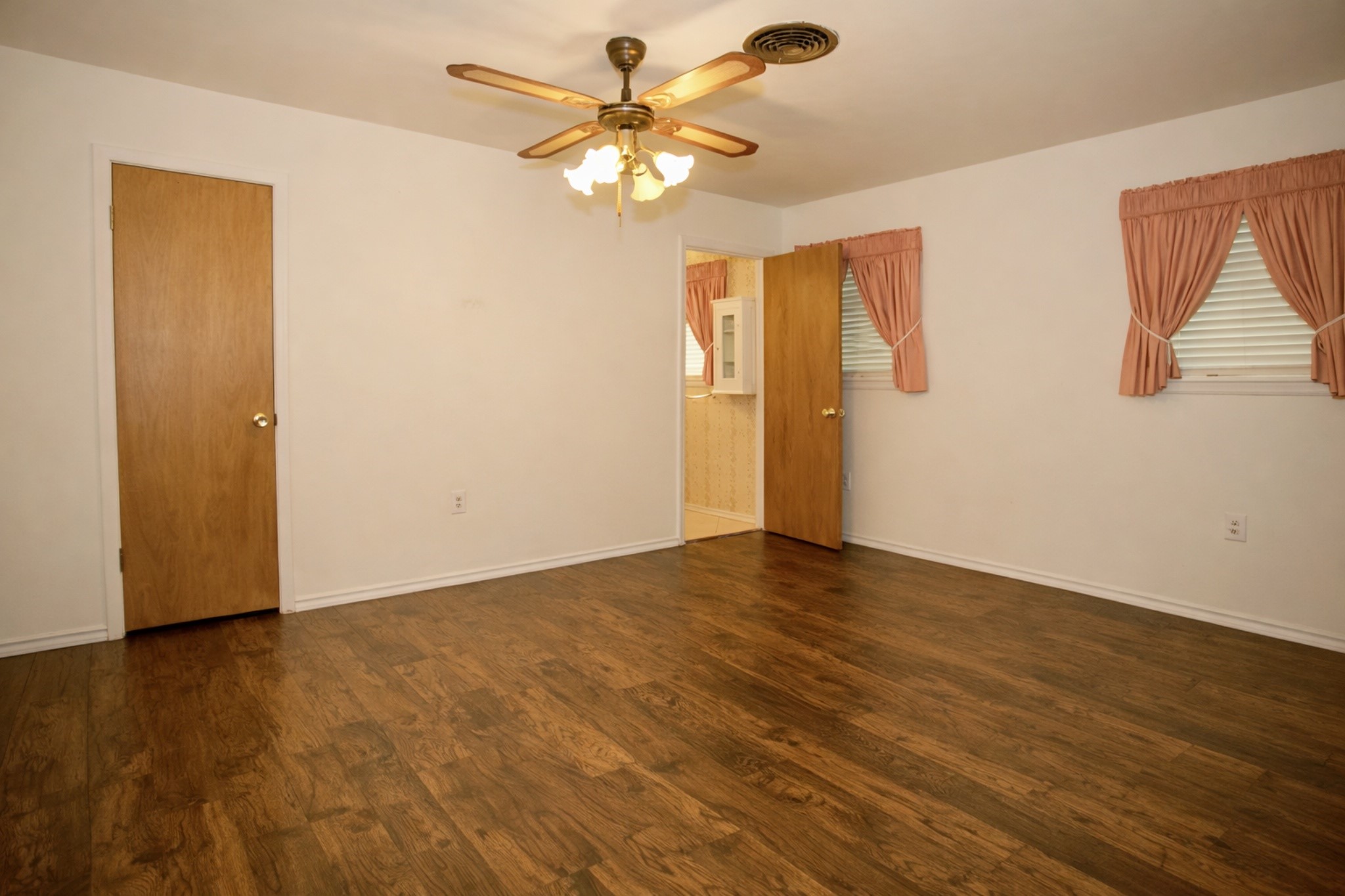 2709 Rebecca Drive Big Spring, TX 79720 - Photo 6 of 16 a view of an empty room with wooden floor and a chandelier fan