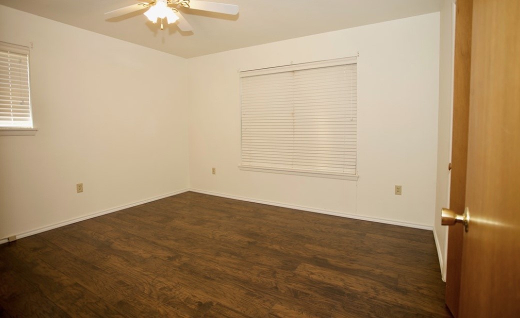 2709 Rebecca Drive Big Spring, TX 79720 - Photo 10 of 16 an empty room with a chandelier fan and windows
