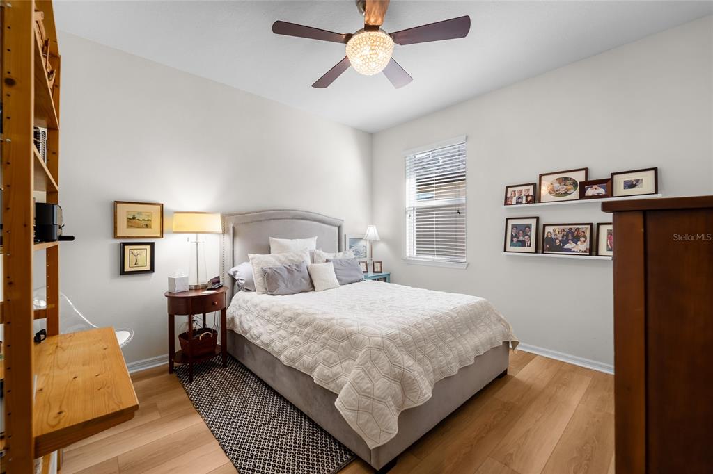 6306 Kenava Loop Palmetto, FL 34221 - Photo 16 of 31 a bedroom with a bed and a chandelier