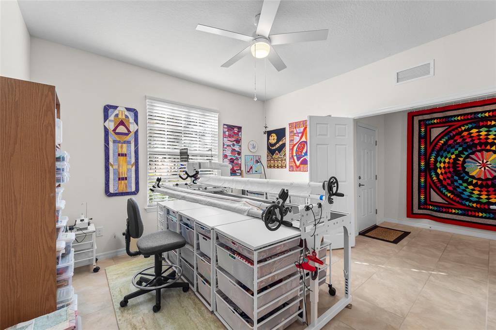 6306 Kenava Loop Palmetto, FL 34221 - Photo 22 of 31 a living room with furniture gym equipment and a chandelier