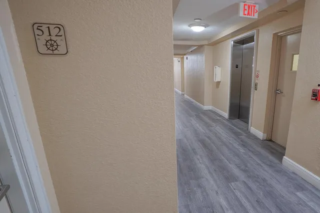 a view of a hallway with wooden floor