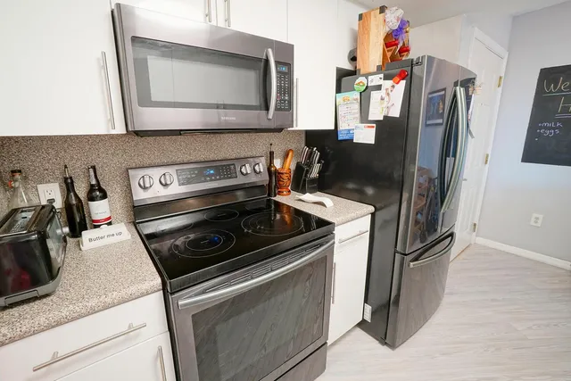 a kitchen with stainless steel appliances granite countertop a refrigerator stove and sink