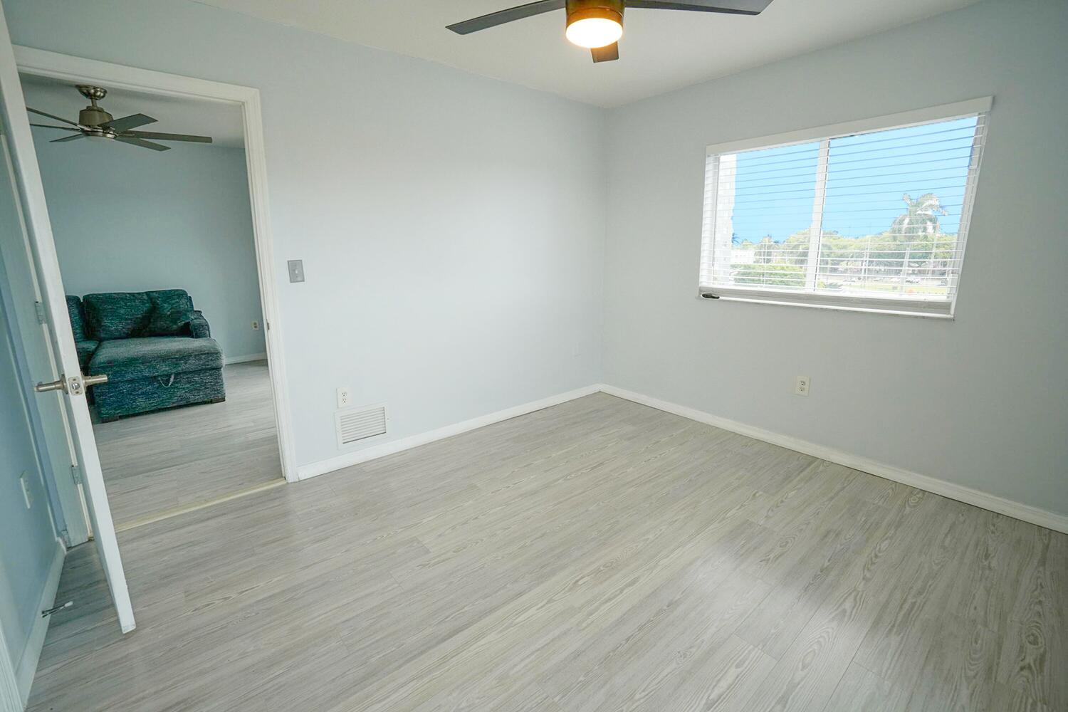 2415 Northwest 16th St Road, Unit 512 Miami, FL 33125 - Photo 8 of 17 an empty room with wooden floor mirror and windows