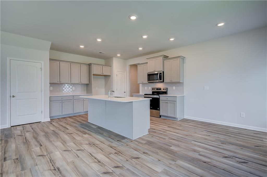 149 St Anne's Place Covington, GA 30016 - Photo 11 of 30 a kitchen with a refrigerator and a stove top oven
