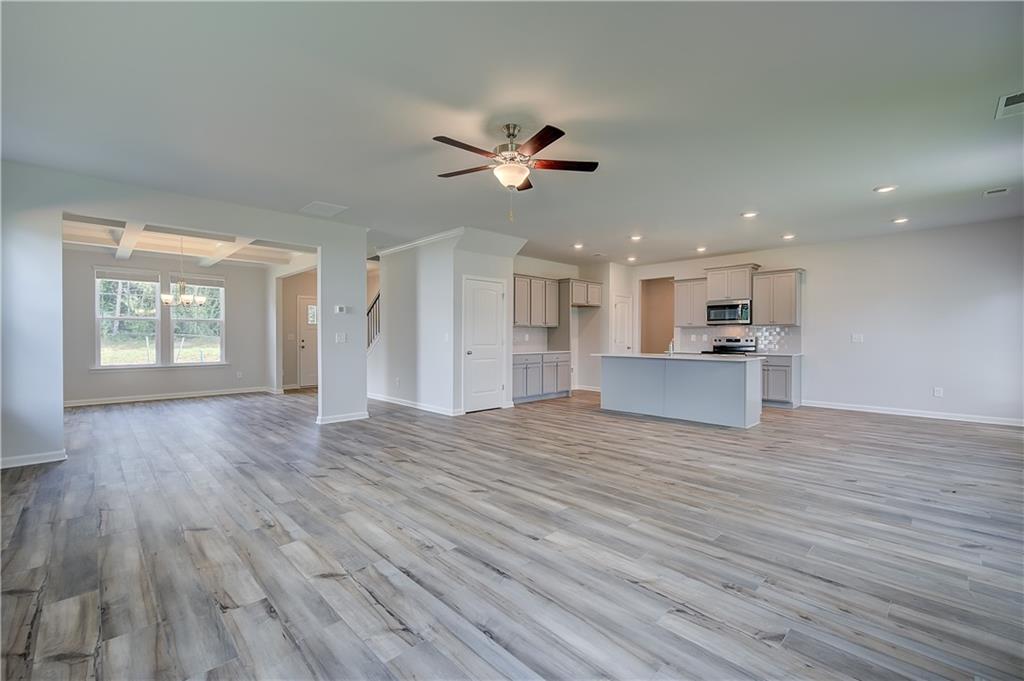 149 St Anne's Place Covington, GA 30016 - Photo 9 of 30 a view of an empty room with window and wooden floor