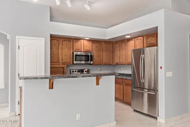 a kitchen with stainless steel appliances a refrigerator sink and microwave