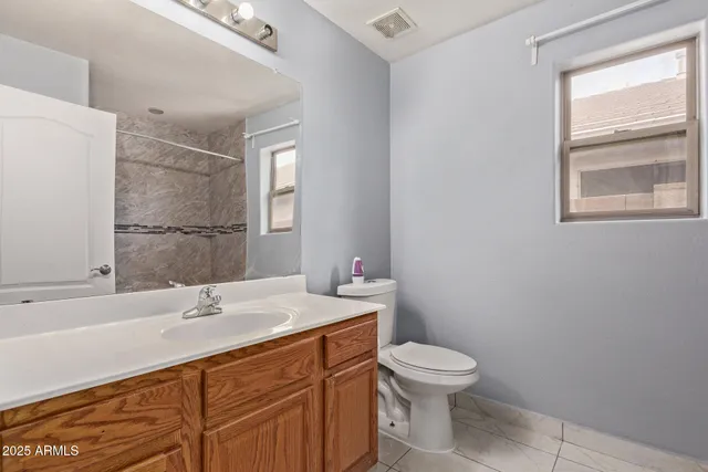 a bathroom with a sink toilet vanity and granite