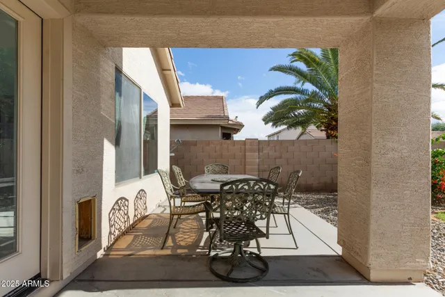 a table with chairs and a vase of flowers