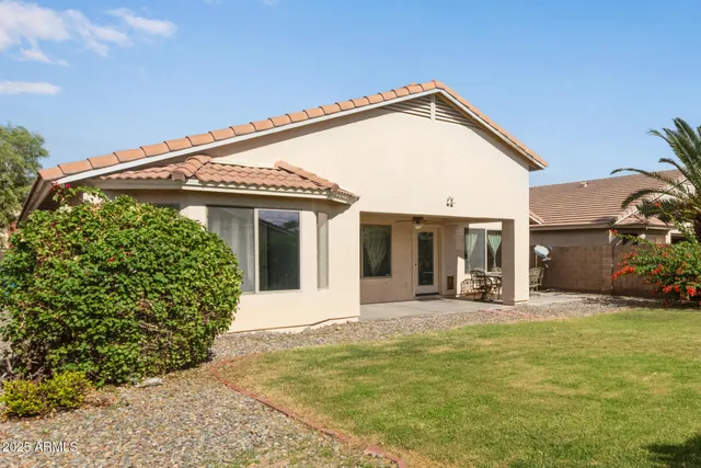 a view of a house with floor to ceiling windows and yard