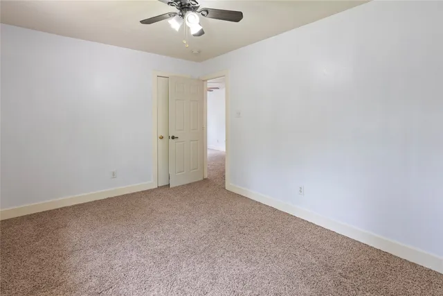an empty room with a chandelier fan