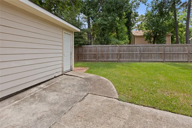 a view of a backyard with grass and a large tree