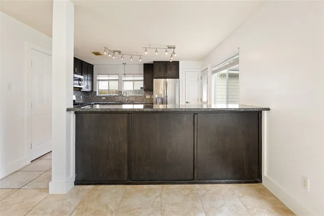 a kitchen with kitchen island sink and refrigerator