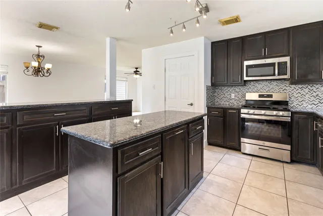 a kitchen with a stove cabinets and microwave