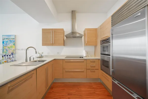 a kitchen with stainless steel appliances a sink stove and refrigerator