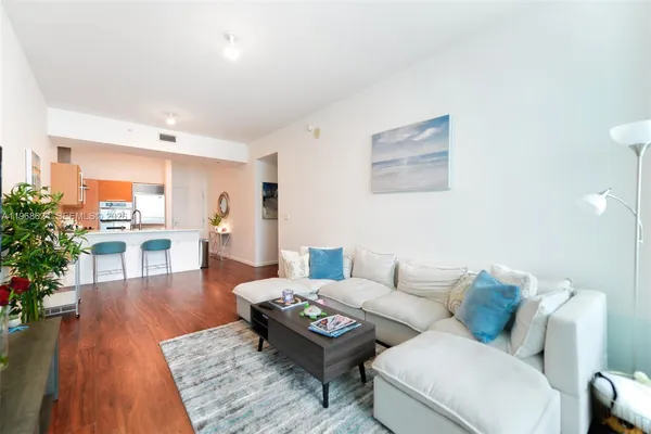 a living room with furniture and a wooden floor