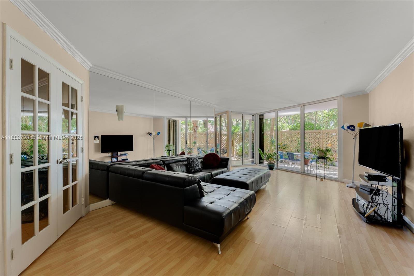 2000 Towerside Terrace, Unit 308 Miami, FL 33138 - Photo 2 of 16 a living room with furniture and a flat screen tv