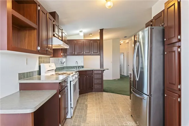 a kitchen with a sink refrigerator and cabinets