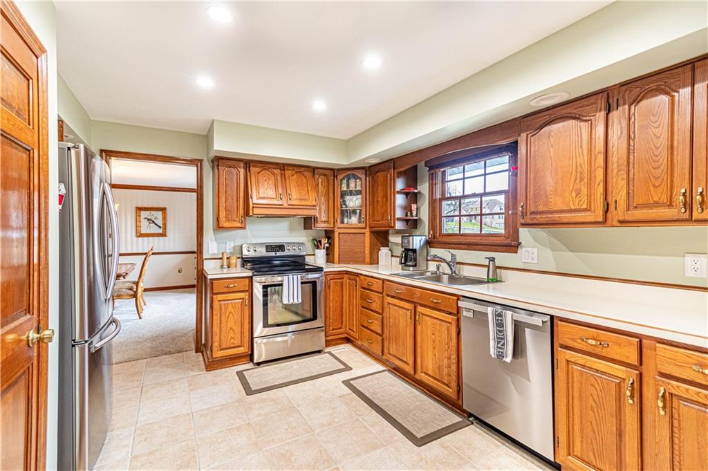 331 Cobblestone Circle McKees Rocks, PA 15136 - Photo 10 of 44 a kitchen with stainless steel appliances granite countertop a stove top oven a sink dishwasher a dining table and chairs with wooden floor
