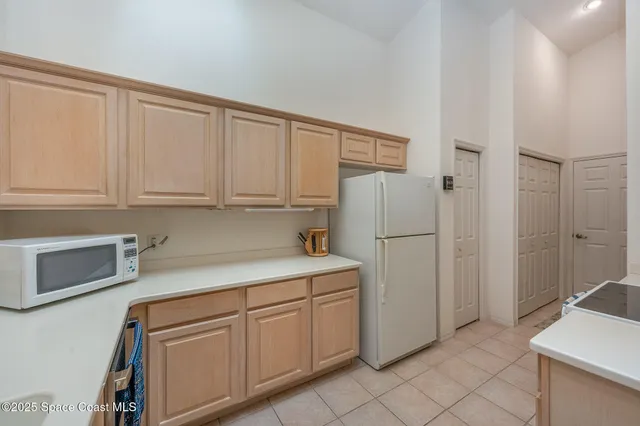 a kitchen with white cabinets and white appliances