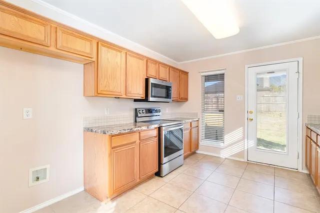 a kitchen with stainless steel appliances granite countertop a stove top oven a sink and a refrigerator