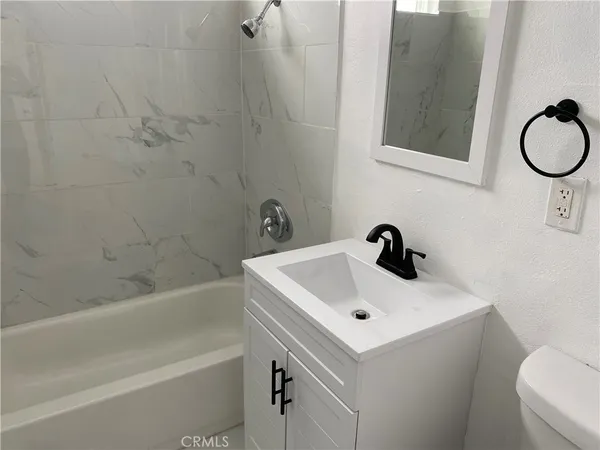 a bathroom with a sink a toilet and bathtub