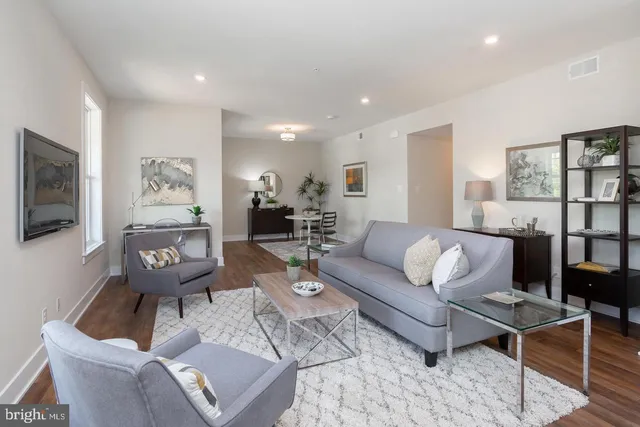 a living room with furniture and paintings on the wall