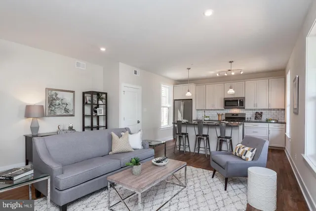 a living room with furniture kitchen view and a table
