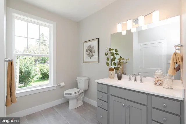 a bathroom with a double vanity sink toilet and a window