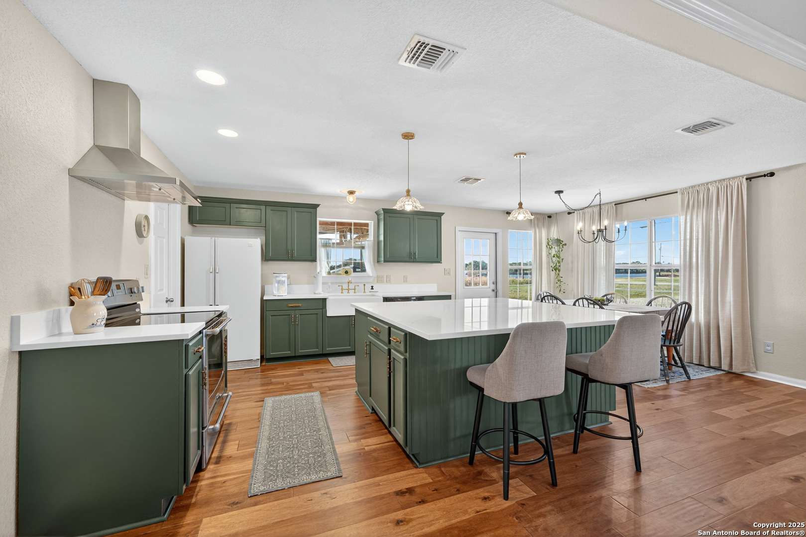 118 Stallion Trail Natalia, TX 78059 - Photo 14 of 35 a kitchen with stainless steel appliances granite countertop a sink a stove a refrigerator cabinets and a dining table