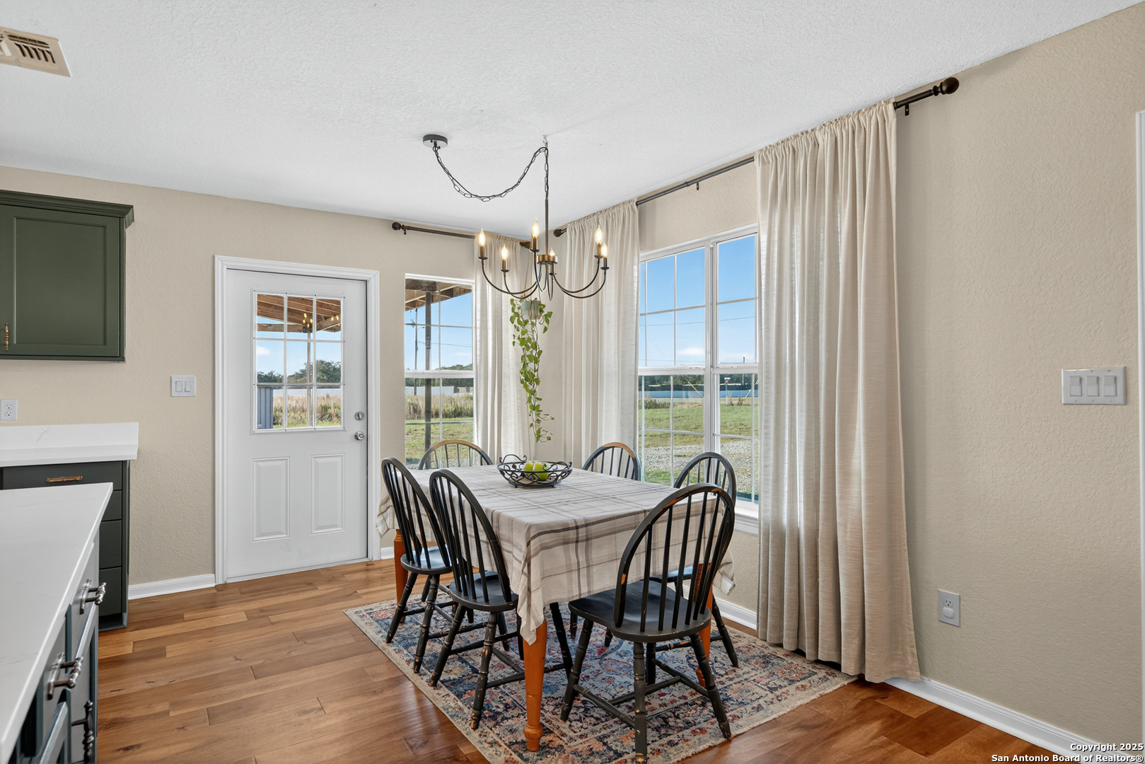 118 Stallion Trail Natalia, TX 78059 - Photo 15 of 35 a dining room with furniture a chandelier and wooden floor