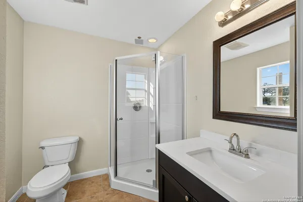a bathroom with a shower sink and mirror