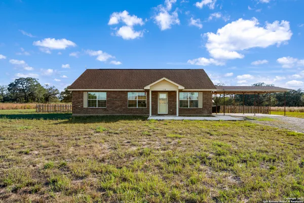a front view of house with yard and lake view in back