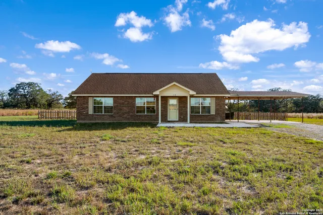 a front view of house with yard and lake view in back