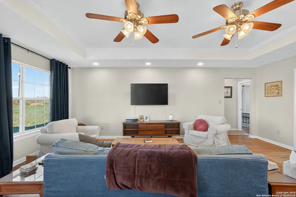 a living room with furniture ceiling fan and a window