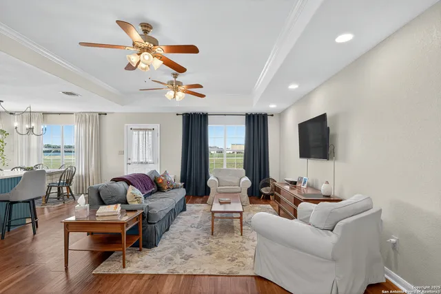 a living room with furniture kitchen view and a large window