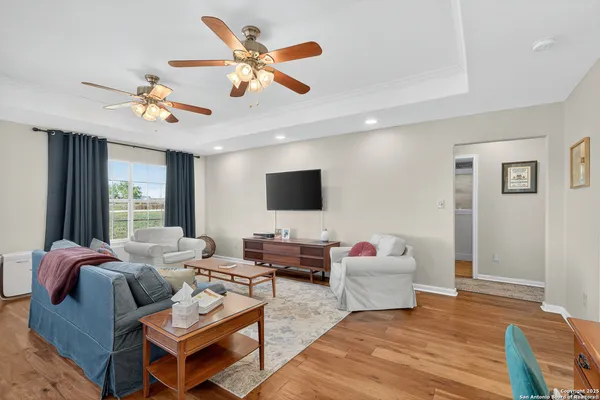 a living room with furniture kitchen view and a large window