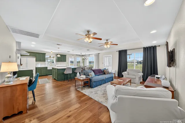 a living room with furniture kitchen view and a large window