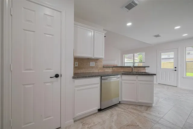 a kitchen with granite countertop white cabinets and white appliances