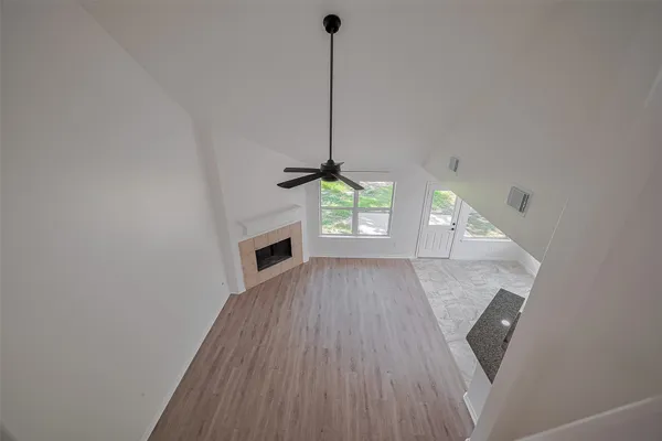 a view of a hallway with wooden floor and a fireplace